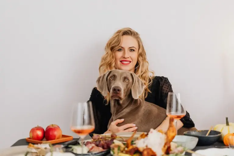 Femme et chien à une table de repas conviviale