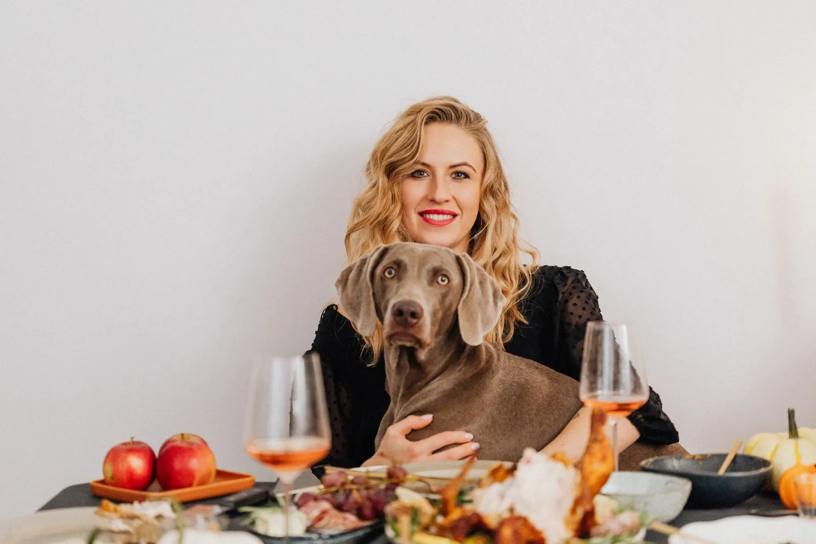 Femme et chien à une table de repas conviviale